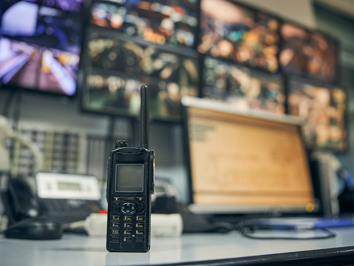 Close-up photo of a walkie-talkie sitting on an office desk in a security control room